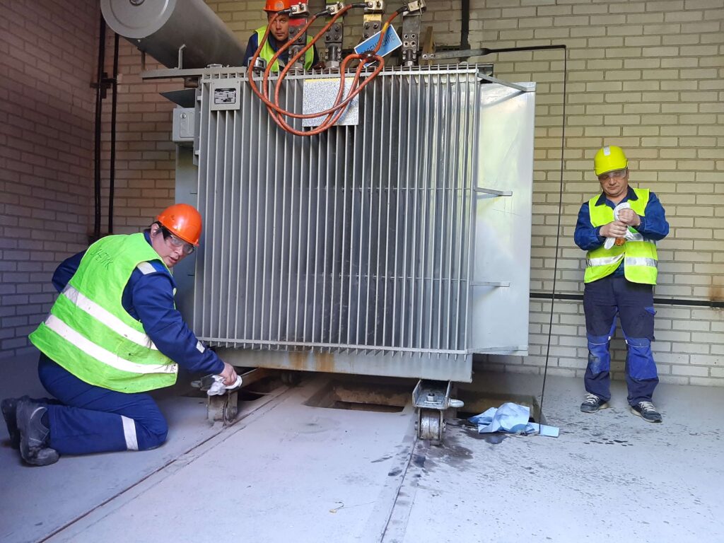 Специалист выполняет обслуживание оборудования трансформаторной подстанции
